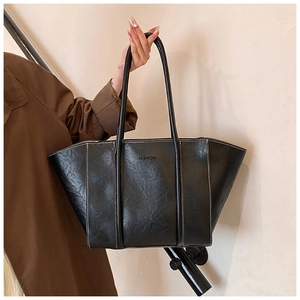 Detail of black PU leather tote bag with white contrast stitching and Fashion print