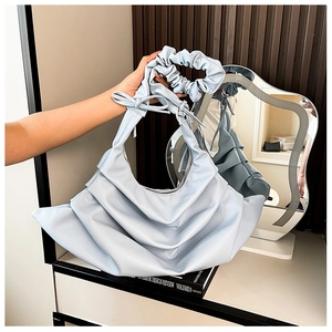 Detail showing the light blue ruched leather texture and scrunchie handle with a bow
