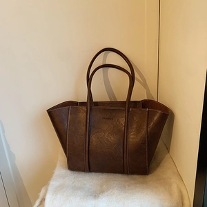 Close-up of dark brown tote bag with vintage texture and FASHION lettering detail