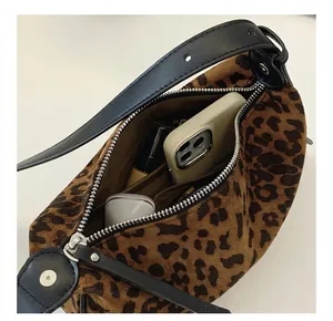 Internal view of leopard print dumpling bag showing phone and lipstick storage space