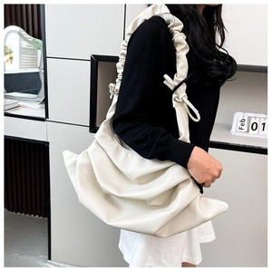 Detail of off-white lychee texture bag featuring stylish drawstring pleated design