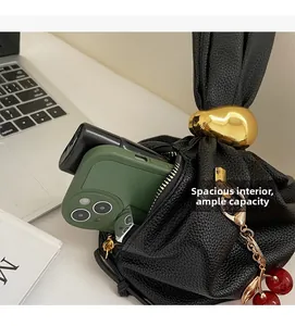 Spacious black lychee grain pleated handbag with gold pebble hardware and cherry charm