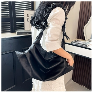 Detail of black pleated shoulder bag with lychee texture PU leather and scrunchie handle