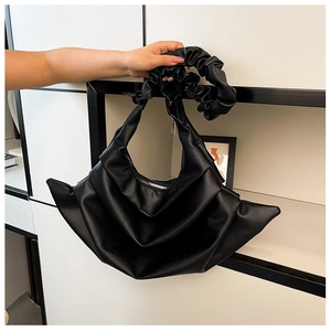Detail showing high-quality black lychee textured leather and stylish horizontal pleats