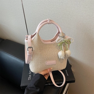 Modische beige Stroh-Beuteltasche mit rosa Lederbesatz und Blumen-Perlen-Anhänger