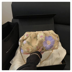 Détails de broderie florale 3D et chaîne dorée sur ce sac nuage beige à paillettes