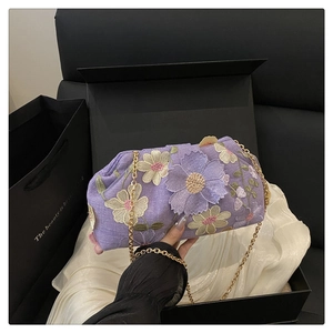 Détails de broderie florale et chaîne dorée sur ce sac de soirée à paillettes violet