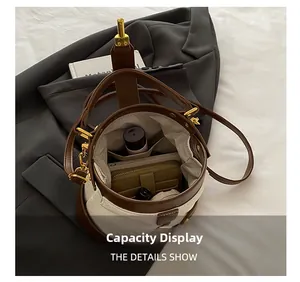 Interior capacity display of minimalist white leather bucket bag with brown trim and gold hardware