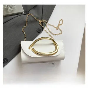 Size comparison of white leather handbag with golden ring handle and a smartphone