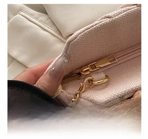 Détail de la pochette de soirée brodée de fleurs roses avec fermeture dorée