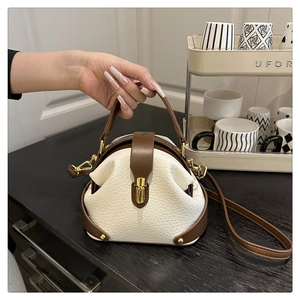 Detail of vintage pebble-textured leather doctor bag with gold hardware and brown straps