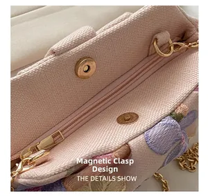 Détail du sac de soirée rose brodé montrant le fermoir magnétique et la chaîne dorée