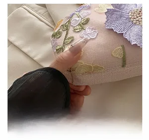 Gros plan des coutures précises et de la broderie florale sur un sac de soirée rose