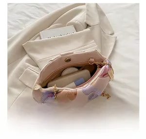 Détails montrant la capacité intérieure et les broderies florales du sac de soirée