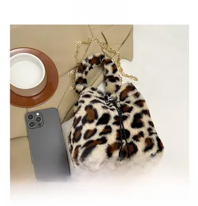 Close-up of leopard print faux fur texture with chain strap and pompom drawstring detail