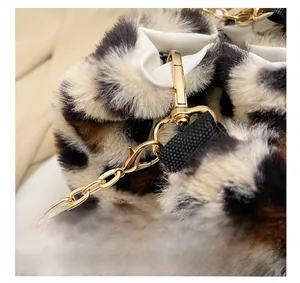 Detail of golden metal chain and D-ring buckle on leopard print plush crossbody bag