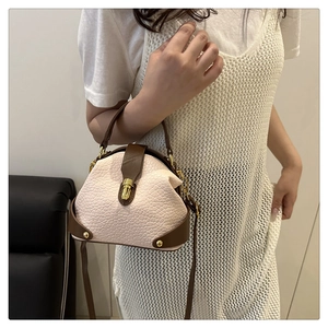 Detail of vintage doctor style mini handbag with grain texture and gold metal clasp