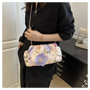 Détail du sac à main rose avec broderies florales 3D et fine bandoulière dorée