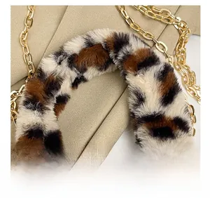 Detail of leopard print faux fur handle with polished gold metal chain on small bag