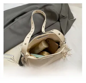Vue intérieure du sac bandoulière crème montrant l'espace pour téléphone et cosmétiques
