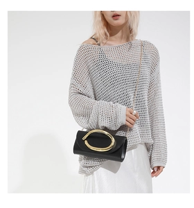 Fashionable black leather flap bag with oversized gold metal buckle and chain strap