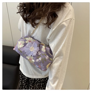 Détail du sac nuage violet avec broderies florales et bandoulière en chaîne dorée