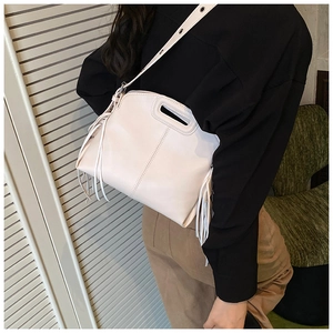 Vue détaillée du sac bandoulière crème avec franges latérales et poignée découpée