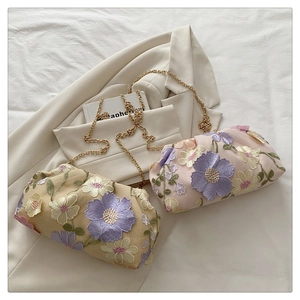 Détails de broderie florale et chaînes dorées sur sacs nuage crème et rose