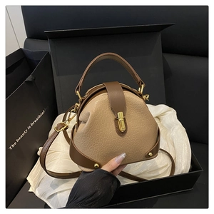 Detail of a textured beige and brown crossbody bag in premium gift box with silk