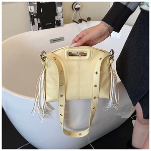 Détail du sac à main jaune pâle avec de longues franges et une bandoulière à œillets