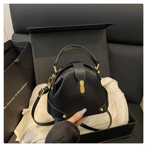Close-up of black crocodile pattern crossbody bag with gold hardware in a gift box