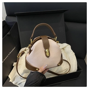 Detail of pink faux crocodile leather handbag with vintage gold buckle and gift packaging