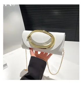 Detailed shot of white leather handbag featuring a large golden oval metal buckle and chain