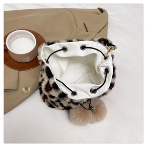 Detail view of leopard print plush bucket bag with drawstring closure and pom-pom detail