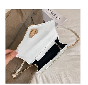 Detail of white glossy crossbody bag showing interior lining and gold heart clasp