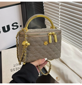Detail of quilted beige crossbody bag with gold-tone hardware and adjustable ball chain
