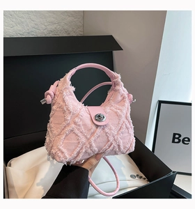 Dettaglio borsa di jeans rosa con texture a frange e fibbia metallica in scatola