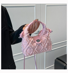 Dettaglio della borsa in denim rosa trapuntato con bordi sfrangiati e fibbia