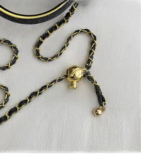 Close-up of golden adjustable metal ball and chain strap on a quilted shoulder bag