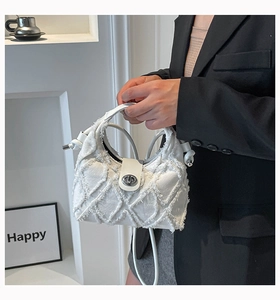 Dettaglio borsa a tracolla in denim bianco con cuciture a frange e chiusura a scatto
