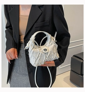 Dettaglio della trama in denim bianco con trapuntatura a rombi e chiusura argentata