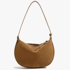 Brown suede minimalist half-moon crossbody bag with top zipper and soft curved silhouette