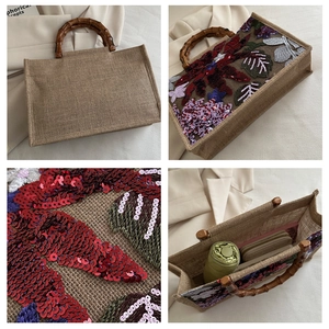 Detail of woven linen handbag with sequin floral embroidery and bamboo top handles