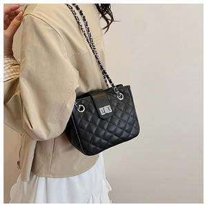 Quilted black chain shoulder bag shown on model for size and drape perspective