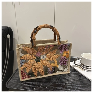 Detail of floral sequin embroidery on burlap tote with carbonized bamboo handle