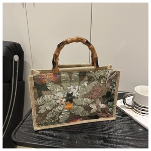 Detail of embroidered floral patterns with sequins on a vintage bamboo handle tote bag