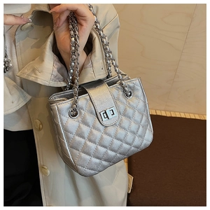 Detailed macro view of the silver quilted leather texture and chain strap on a women handbag
