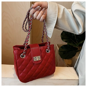 Detail of red quilted leather handbag showing silver chain and metallic turn-lock closure