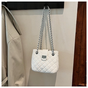 Detail of white quilted leather shoulder bag with silver chain strap and metal turn lock