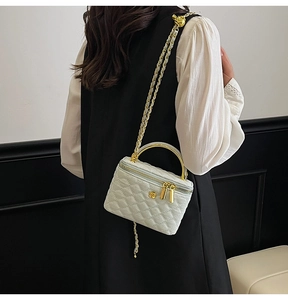 Quilted mint green chain crossbody bag with golden handle shown on a model